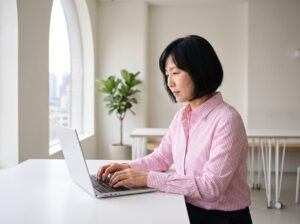 Mujer escribiendo en su portátil en una oficina luminosa